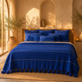 Majorelle Blue Pompom bedspread styled on a bed in a Moroccan bedroom