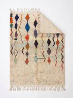 Diamond Cascade Beni Ourain rug folded corner on white studio background