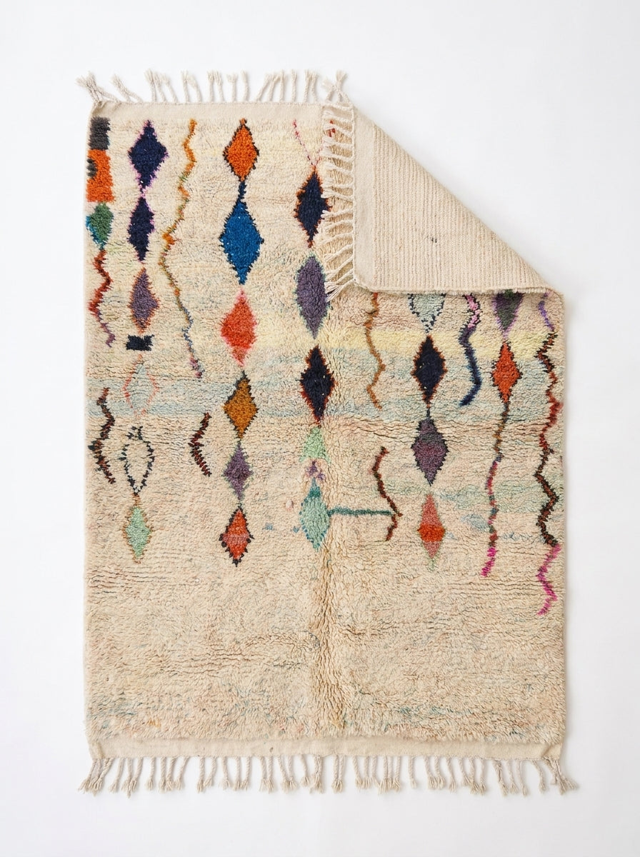 Diamond Cascade Beni Ourain rug folded corner on white studio background