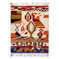 Saffron and ivory Boujaad rug with orange, red and olive geometry and blue band, flat lay