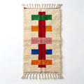 Colorful Moroccan runner rug — cream wool with red spine and green, orange, pink and blue crossbars, flat lay