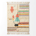 Pastel rainbow Azilal rug — cream wool with colorful stripes and coral totem, flat lay