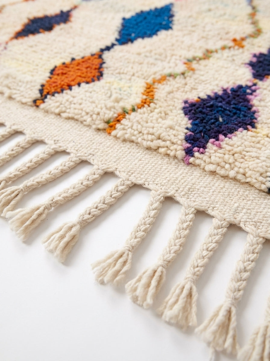 Diamond Cascade Beni Ourain rug fringe detail on white studio background