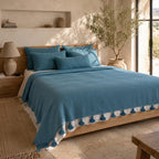 Atlas Teal Tassel bedspread styled on a bed in a Moroccan bedroom