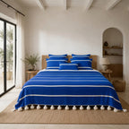 Riviera Stripe Pompom bedspread styled on a bed in a Moroccan bedroom