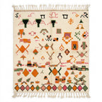 Bordered Blossom Azilal rug, handwoven wool with pink, green, orange and black motifs with a diamond border, flat lay top view