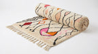 Zigzag Bloom Beni Ourain rug half-rolled on white studio background
