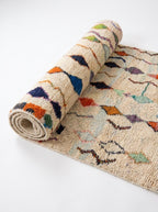 Diamond Cascade Beni Ourain rug half-rolled on white studio background