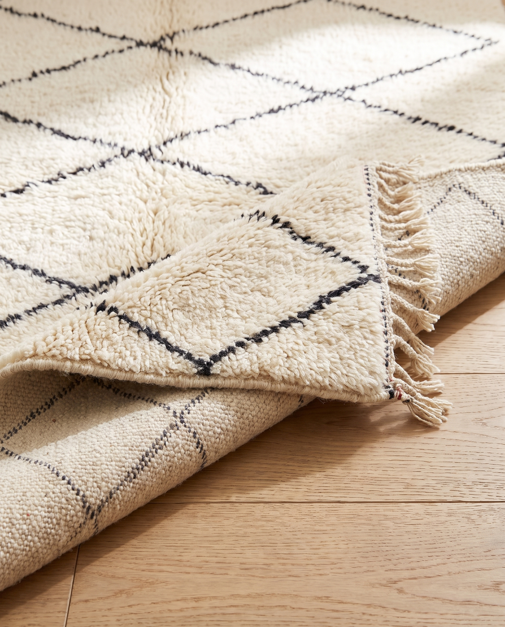 Folded corner showing thick wool pile height and handwoven back — Beni Ourain rug