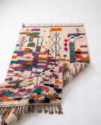 Half-rolled Boujaad rug showing pile thickness on white studio background