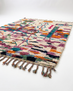 Side view of Boujaad rug showing wool pile height and fringe on white studio background