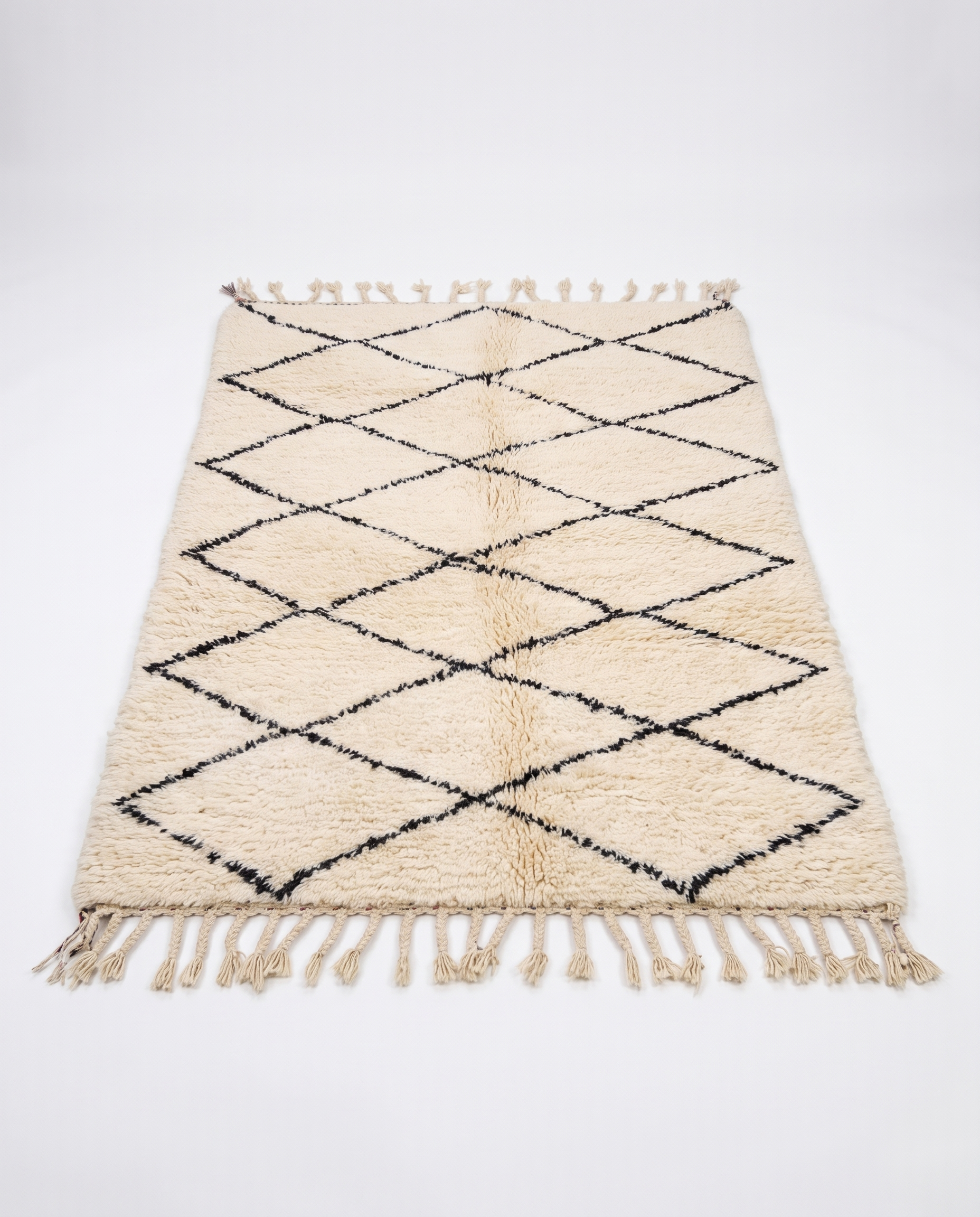 Cream Beni Ourain rug full view at an angle on white studio background