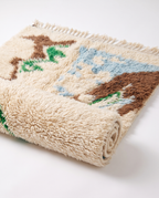 Half-rolled Mrirt rug showing plush wool pile on white studio background