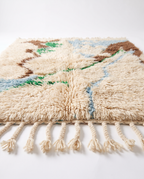 Side view of Mrirt rug showing wool pile height and braided fringe on white studio background