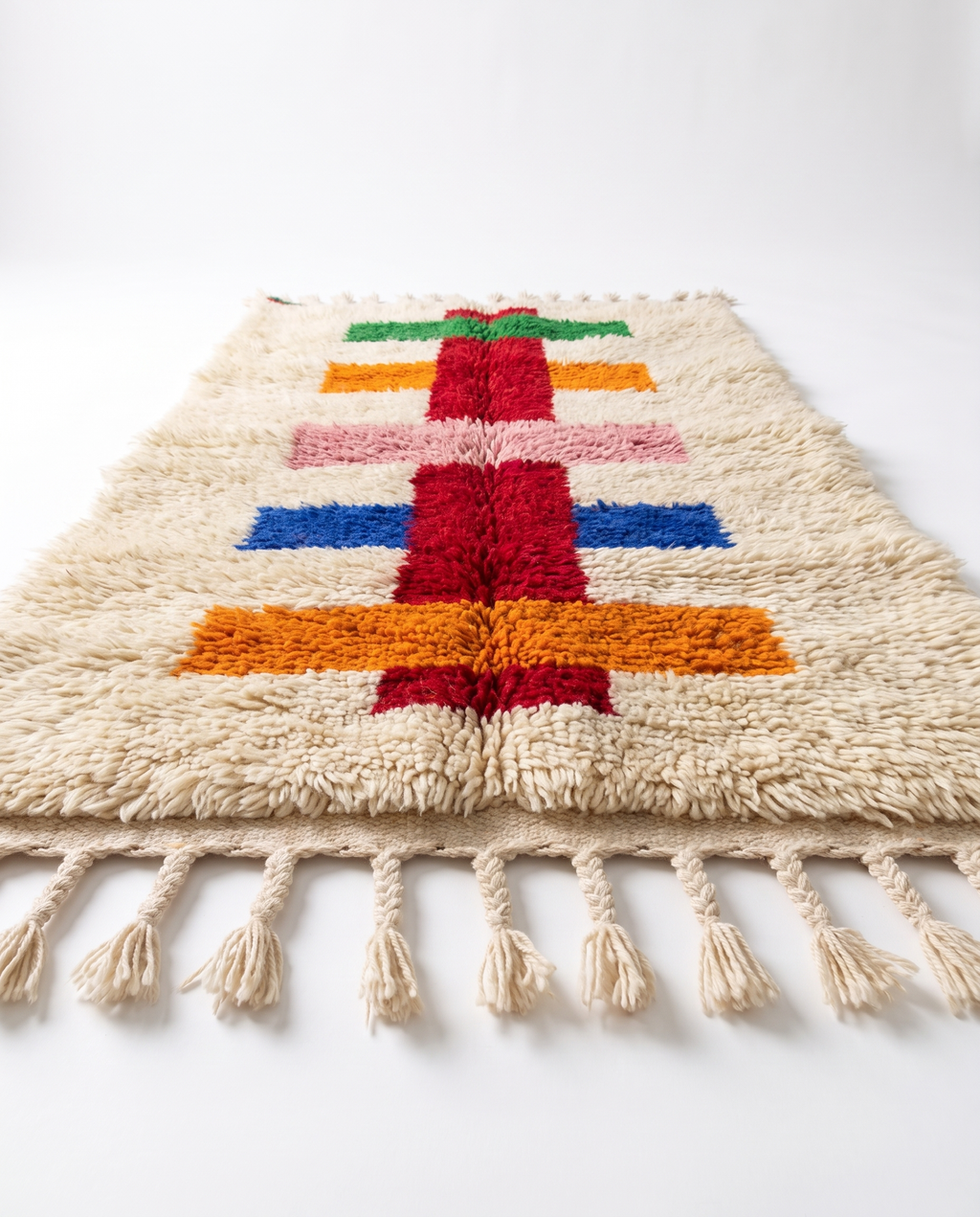 Side view along colorful runner rug showing pile height and fringe on white studio background
