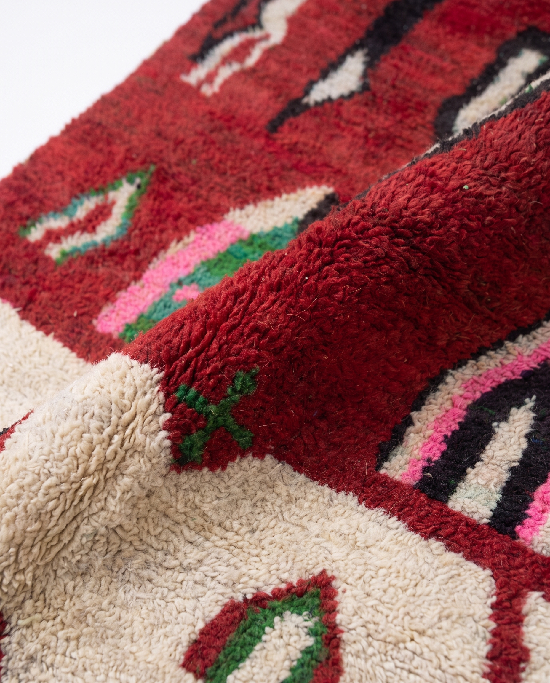 Crimson Boujaad rug wool pile texture close-up on white studio background