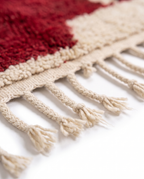Crimson Boujaad rug hand-braided fringe detail on white studio background