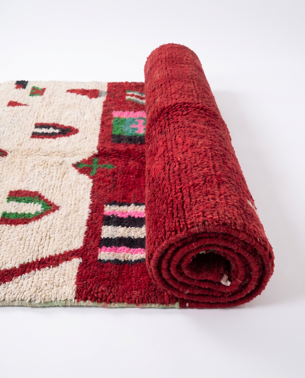 Crimson Boujaad rug half-rolled on white studio background
