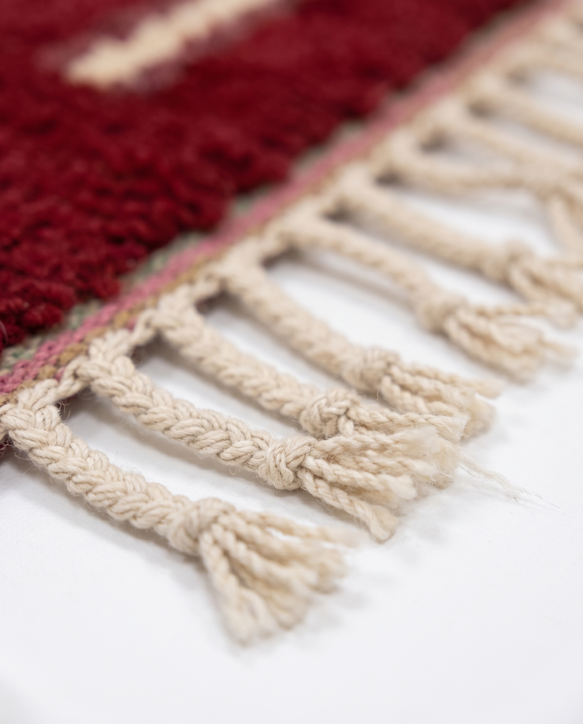 Burgundy and ivory Boujaad rug fringe detail on white studio background