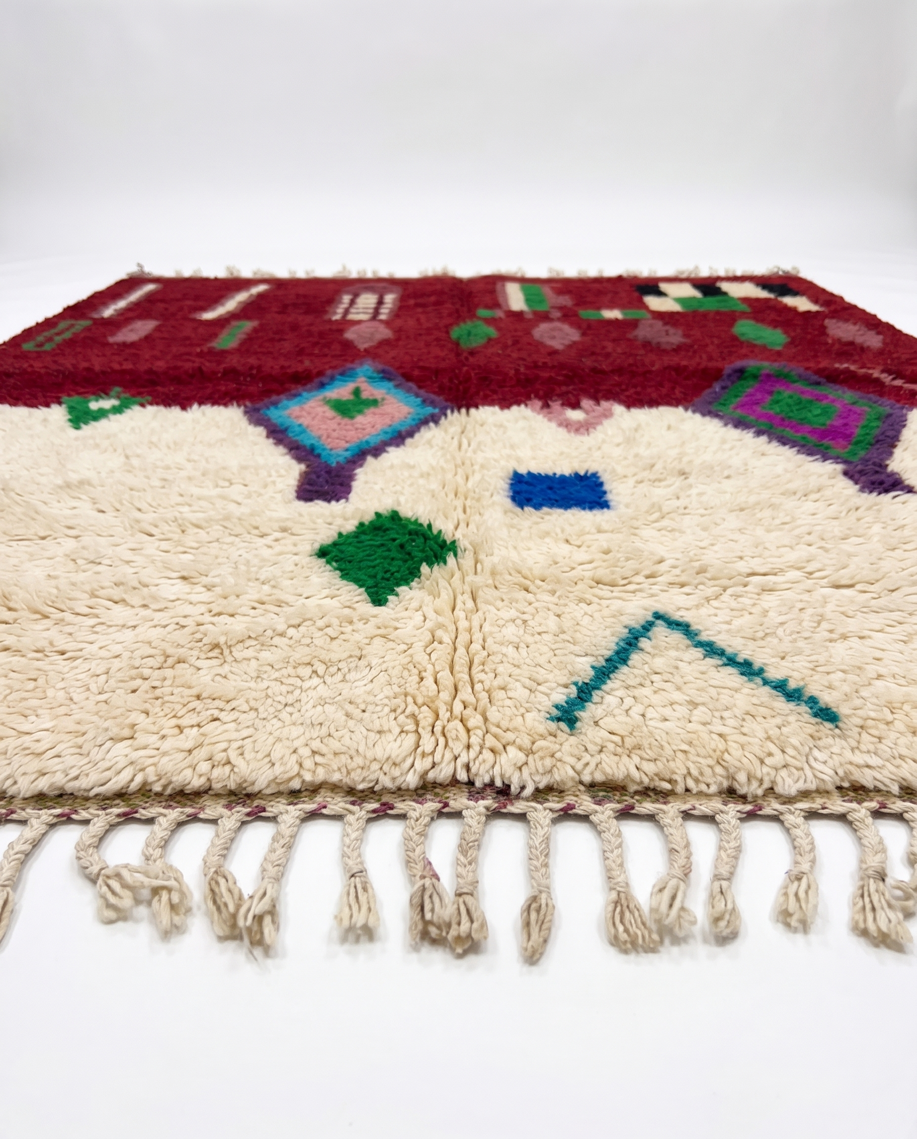 Burgundy and ivory Boujaad rug side view on white studio background