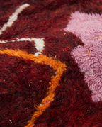 Wine red Boujaad rug wool pile texture close-up on white studio background