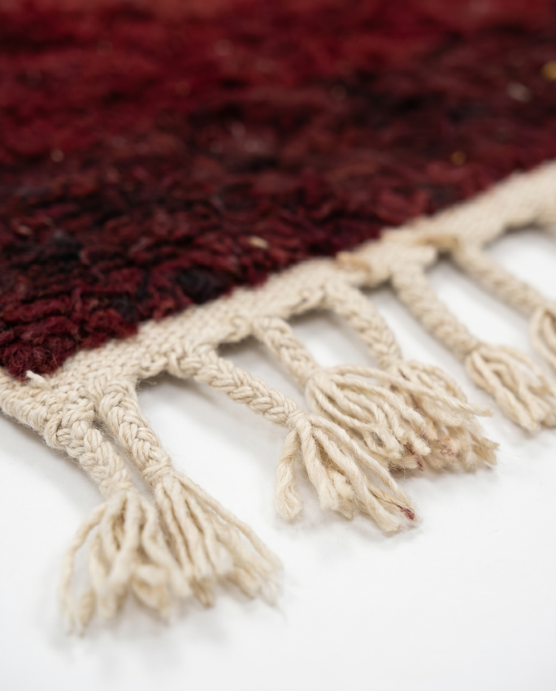 Wine red Boujaad rug fringe detail on white studio background