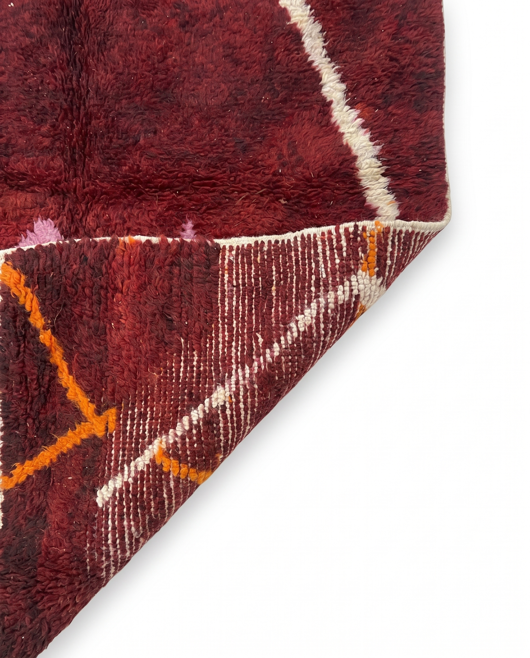 Wine red Boujaad rug folded corner on white studio background