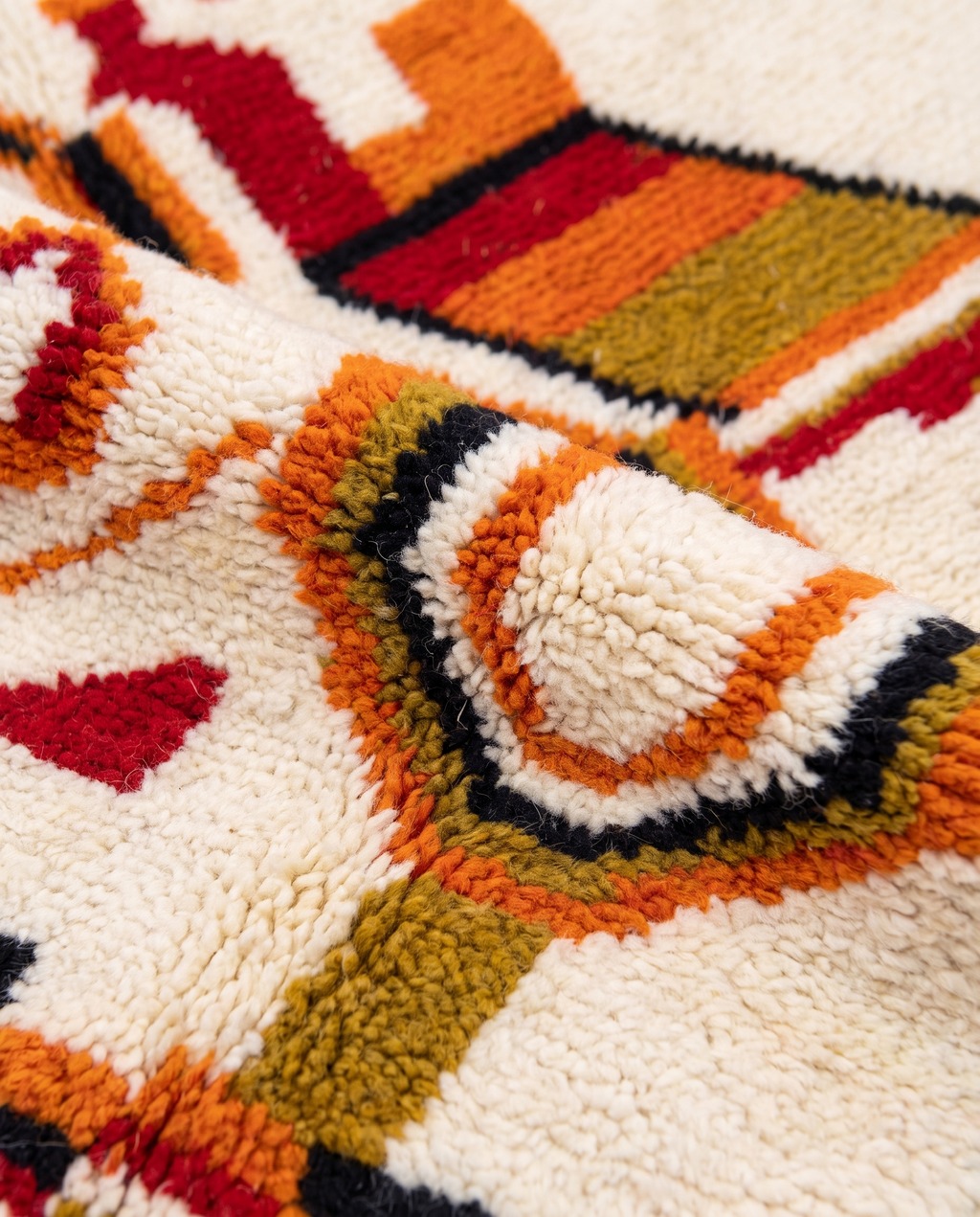 Saffron and ivory Boujaad rug wool pile texture close-up on white studio background