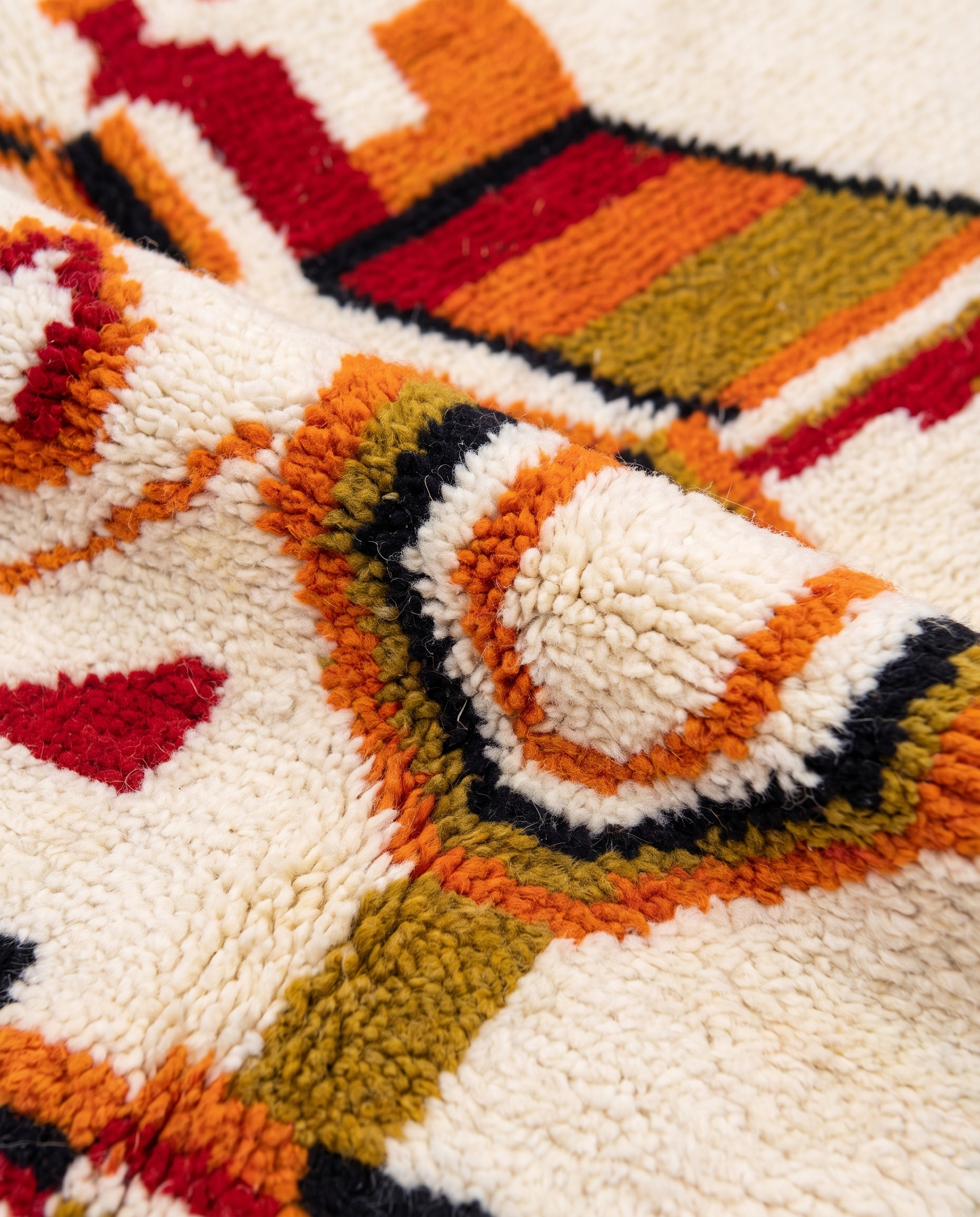 Saffron and ivory Boujaad rug wool pile texture close-up on white studio background