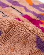Blush terracotta Boujaad rug wool pile texture close-up on white studio background