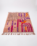 Blush terracotta Boujaad rug full view at an angle on white studio background