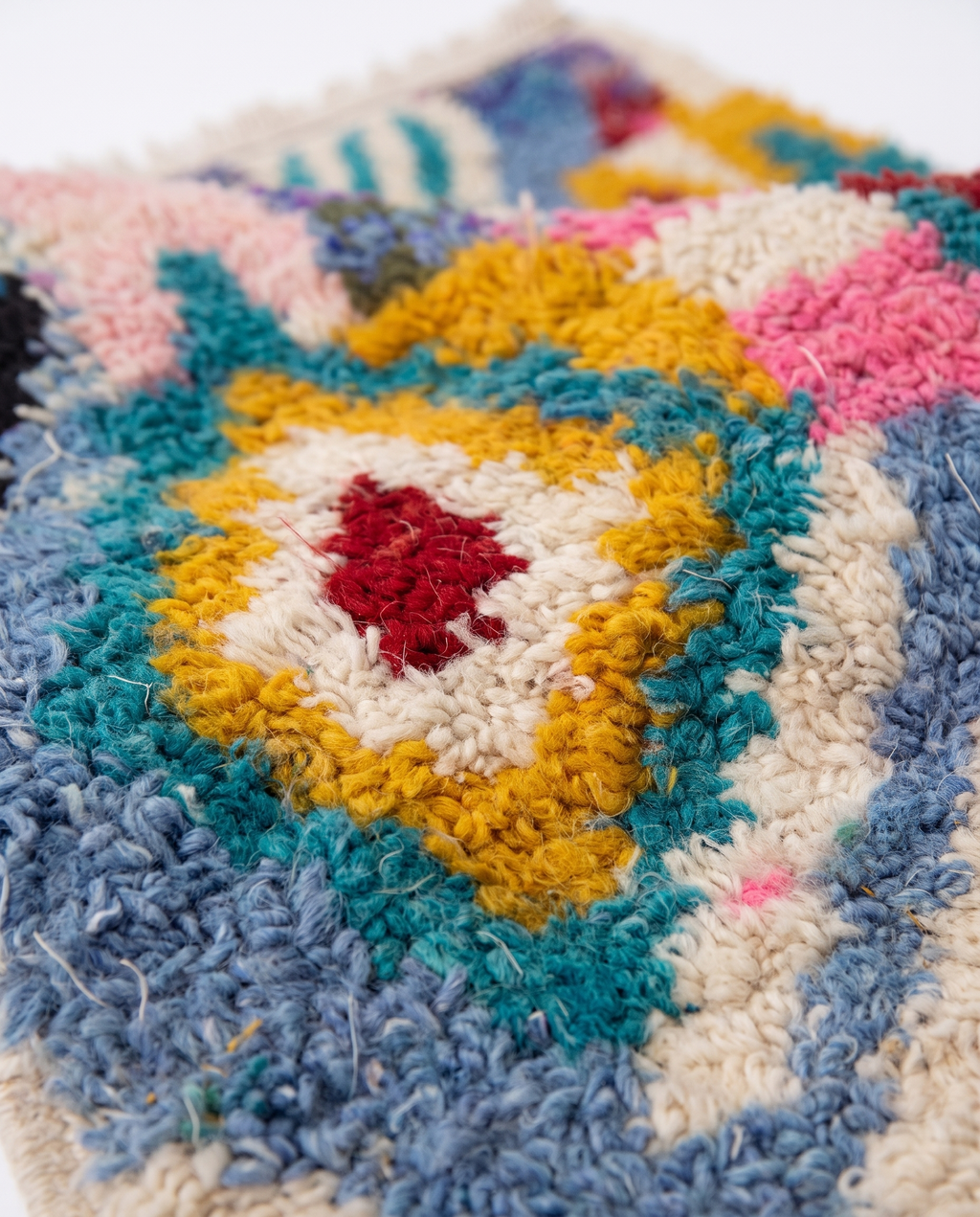 Kaleidoscope Boujaad rug wool pile texture close-up on white studio background