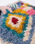 Kaleidoscope Boujaad rug wool pile texture close-up on white studio background
