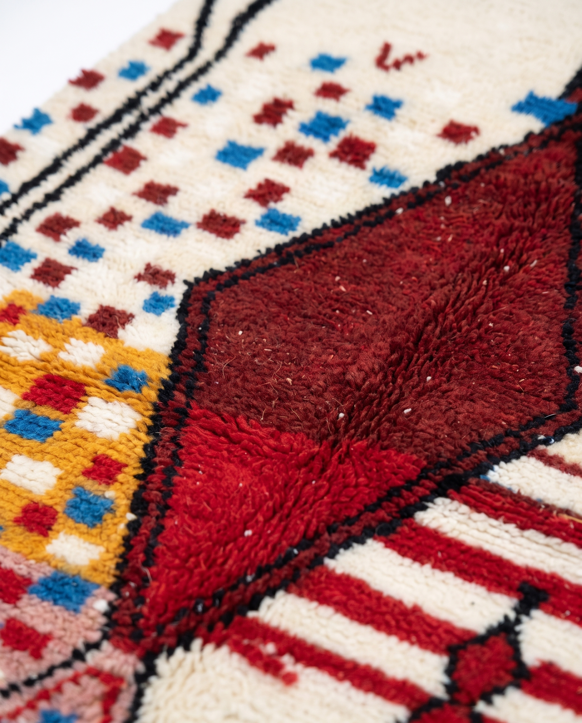 Garnet diamond Boujaad rug wool pile texture close-up on white studio background