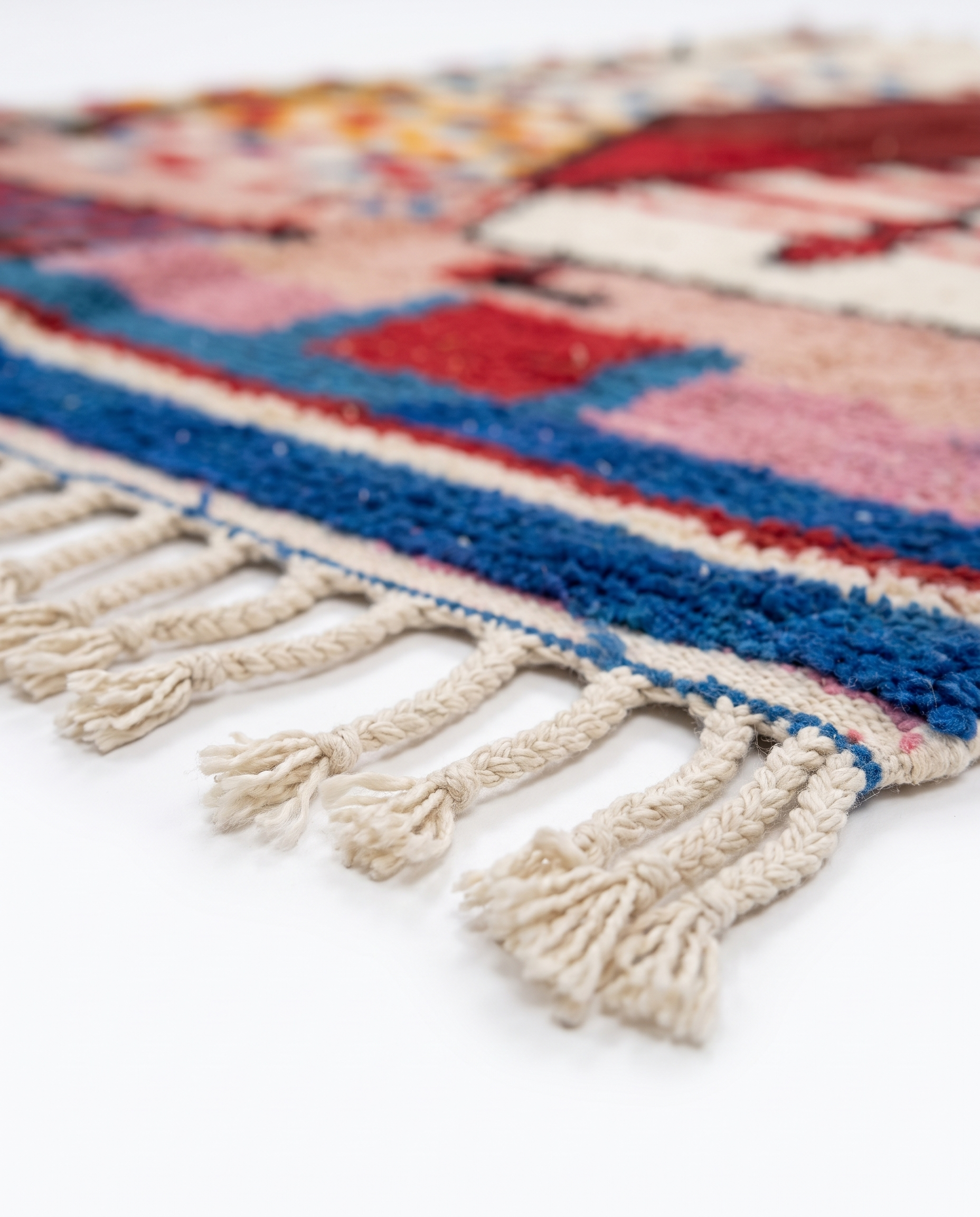 Garnet diamond Boujaad rug fringe detail on white studio background