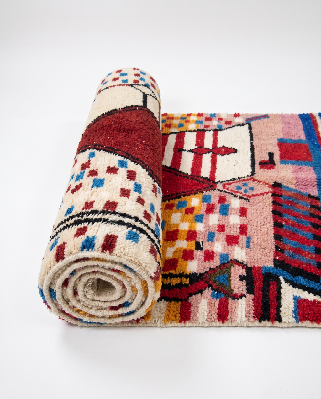 Garnet diamond Boujaad rug half-rolled on white studio background
