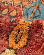 Rust and amber Boujaad rug wool pile texture close-up on white studio background