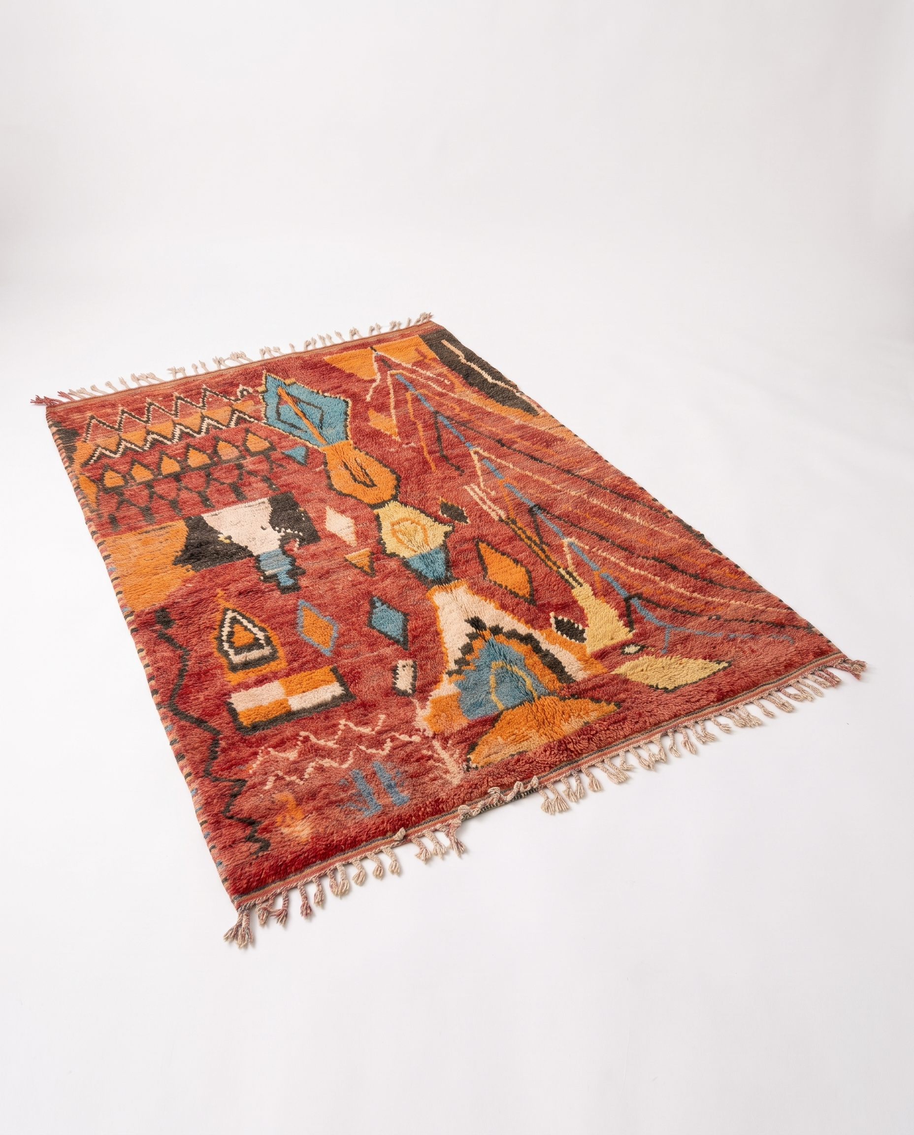 Rust and amber Boujaad rug full view at an angle on white studio background