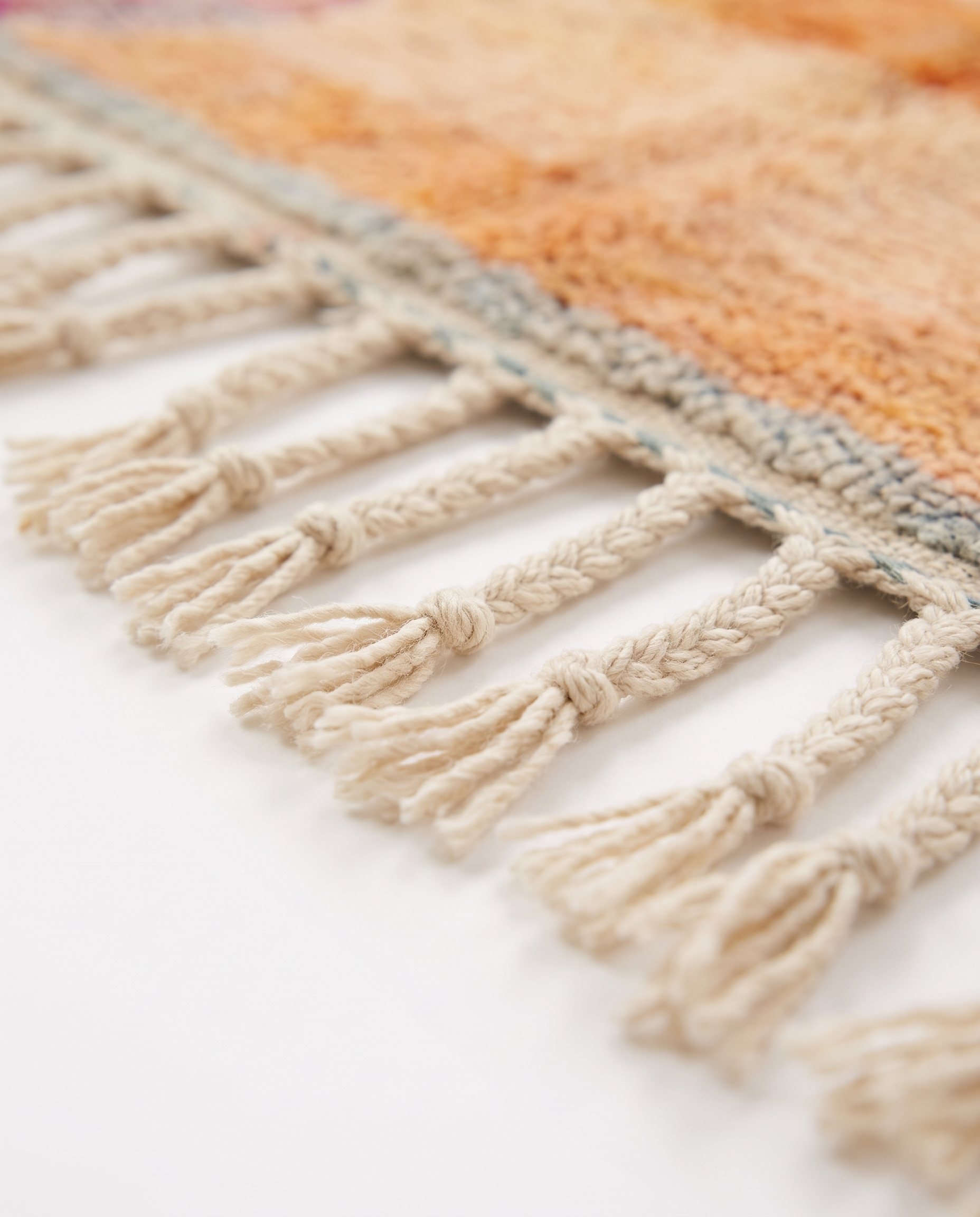 Apricot patchwork Boujaad rug fringe detail on white studio background