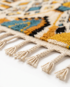 Mustard and teal Boujaad rug fringe detail on white studio background