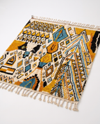 Mustard and teal Boujaad rug full view at an angle on white studio background