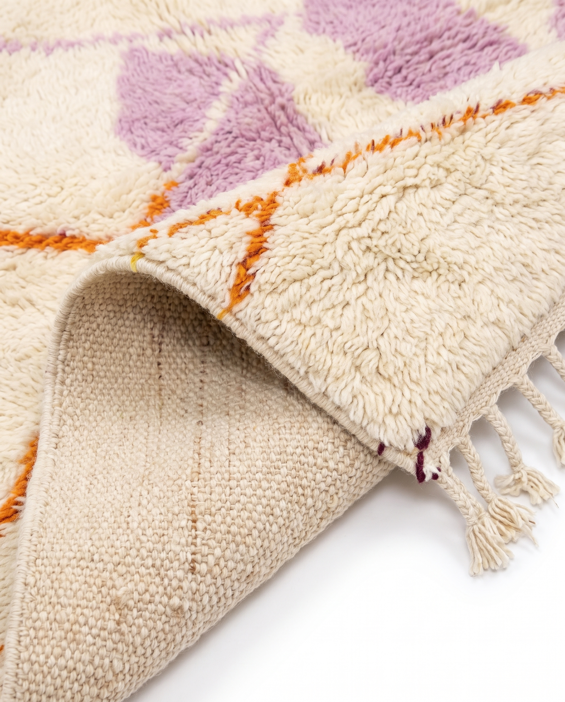 Lilac and tangerine Azilal rug folded corner on white studio background