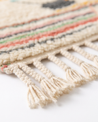 Pastel rainbow Azilal rug fringe detail on white studio background