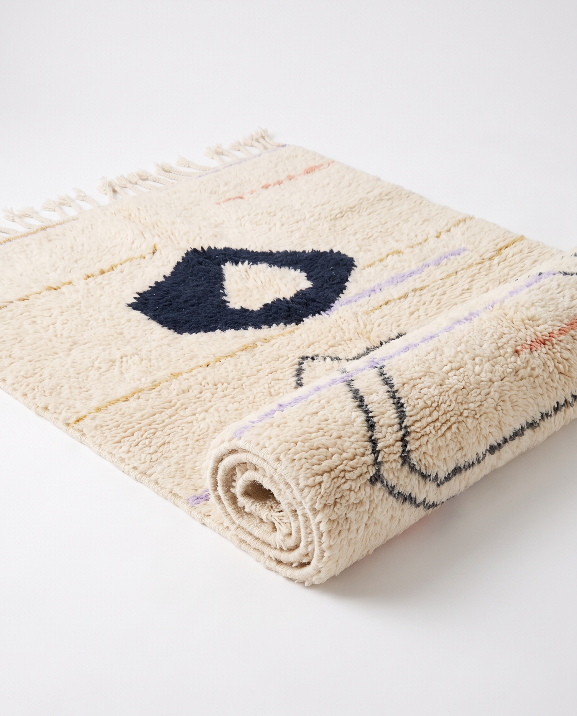 Midnight pebble Azilal rug half-rolled on white studio background