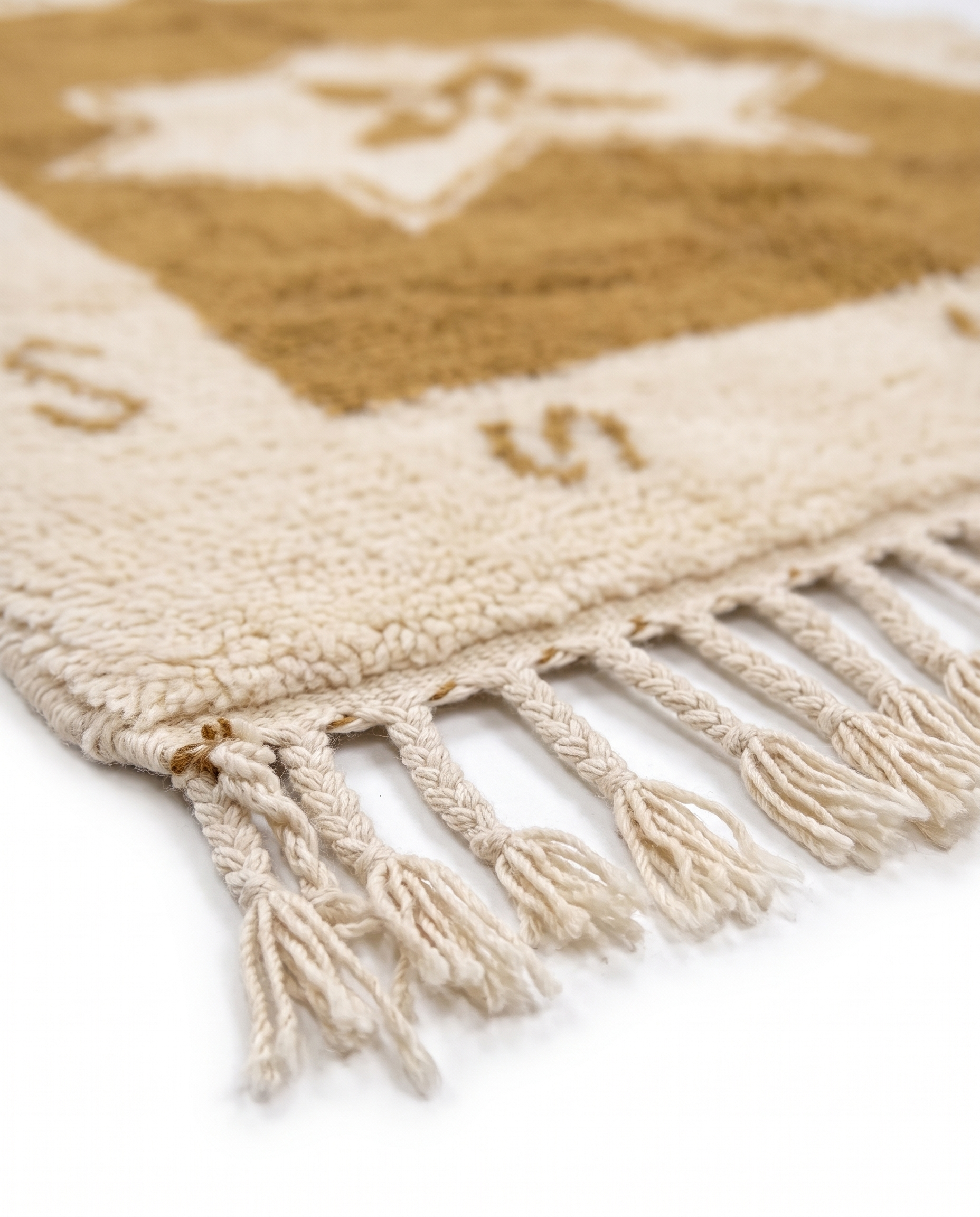 Ochre star Azilal rug fringe detail on white studio background