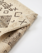 Tribal tales Azilal rug folded corner on white studio background