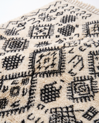 Berber script Azilal rug wool texture close-up on white studio background