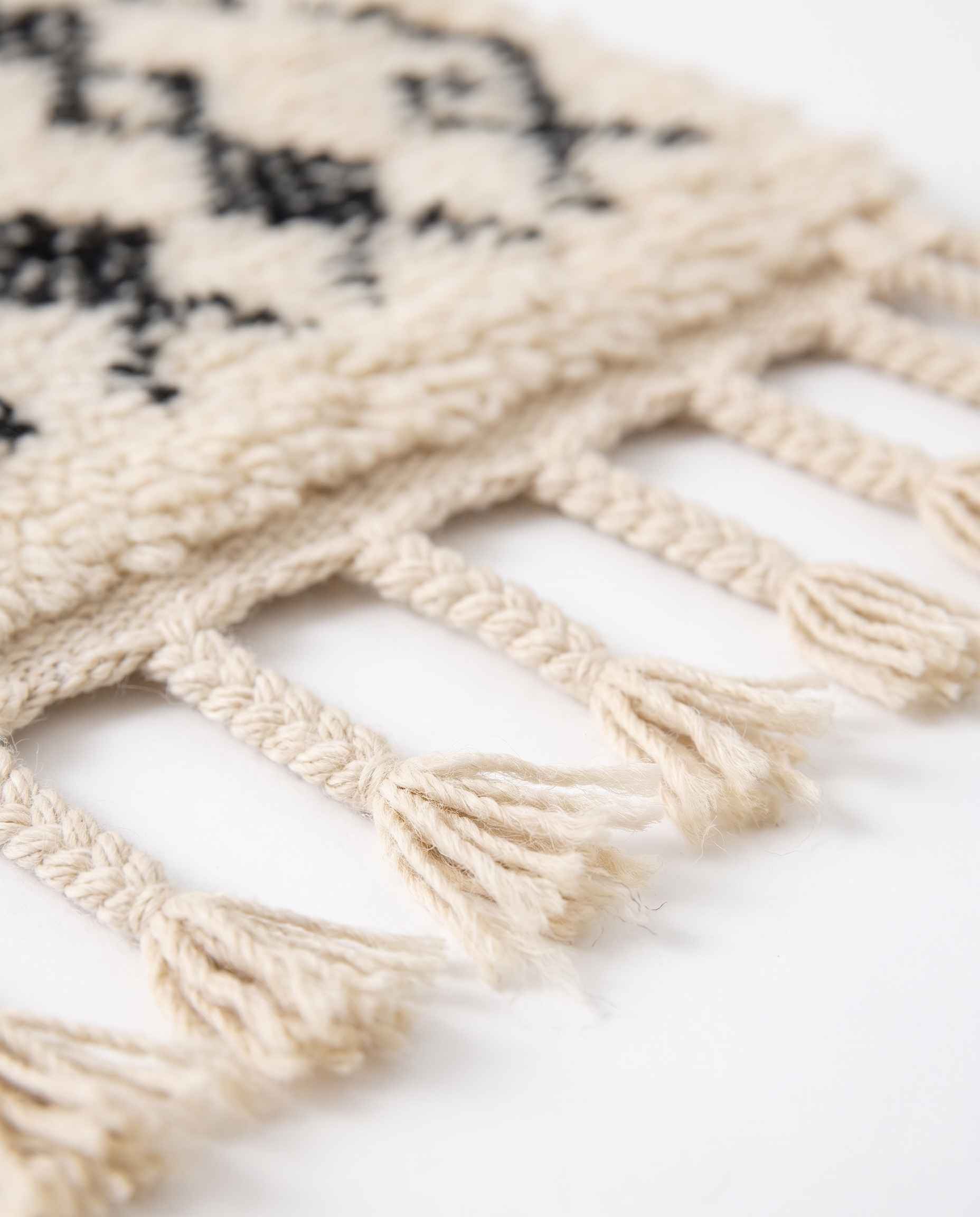 Berber script Azilal rug fringe detail on white studio background