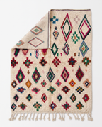 Confetti Diamonds Beni Ourain rug folded corner on white studio background