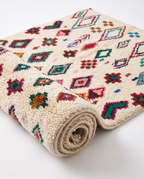 Confetti Diamonds Beni Ourain rug half-rolled on white studio background